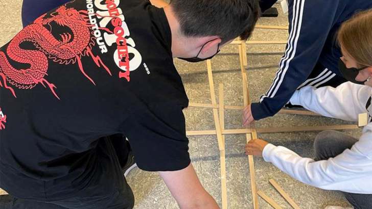 Jugendliche arbeiten mit Holzstäben